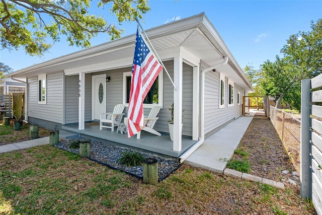 view of front of house featuring covered porch and fence