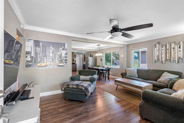 living area featuring ceiling fan with notable chandelier, crown molding, wood finished floors, and baseboards