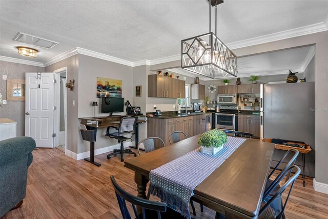 dining room featuring visible vents, light wood-style flooring, crown molding, and baseboards