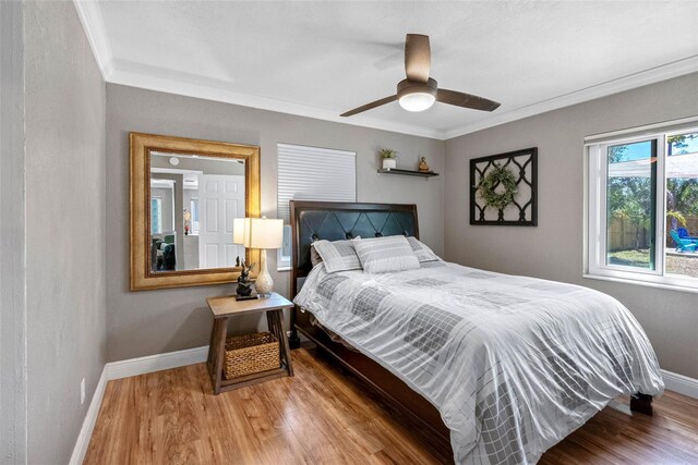 bedroom featuring ornamental molding, ceiling fan, baseboards, and wood finished floors