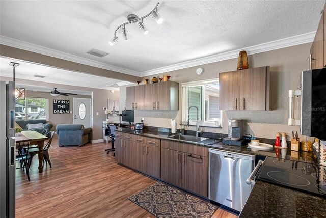 kitchen featuring visible vents, open floor plan, light wood-style flooring, appliances with stainless steel finishes, and a sink