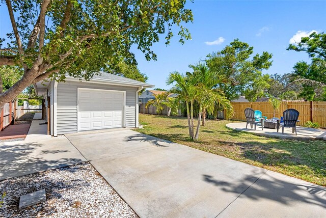 garage featuring driveway and fence