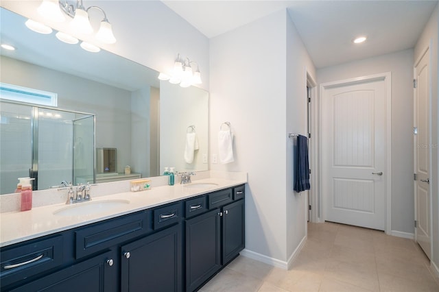 bathroom with tile patterned flooring, a stall shower, double vanity, and a sink