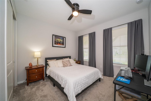 carpeted bedroom featuring baseboards and a ceiling fan