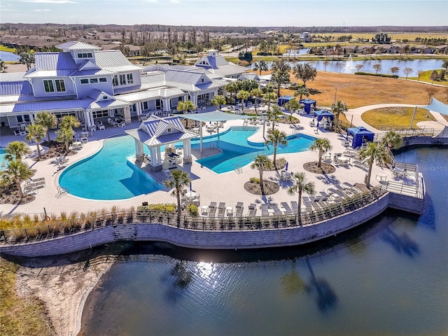 community pool with a patio area and a water view