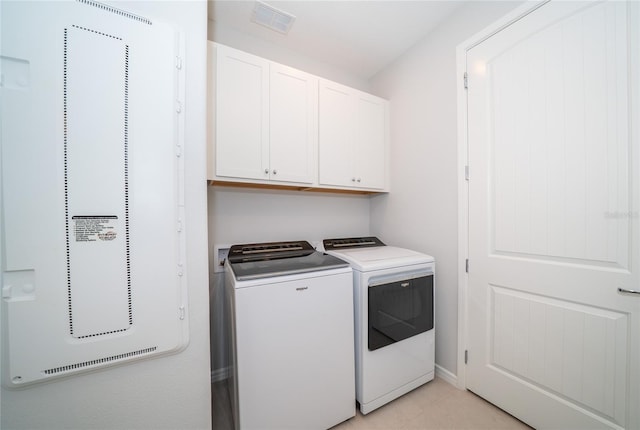 clothes washing area featuring visible vents, cabinet space, and washing machine and dryer