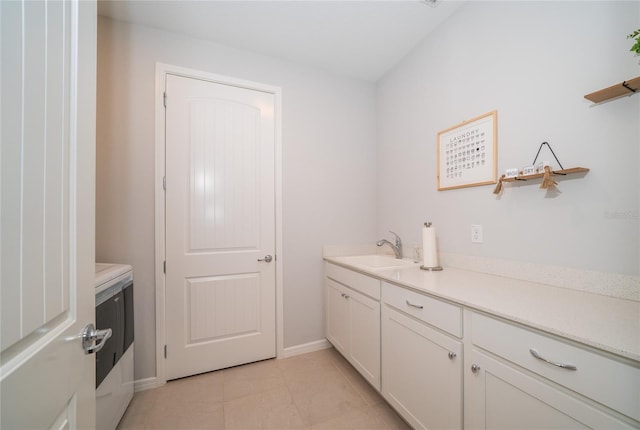 laundry area featuring laundry area, light tile patterned floors, baseboards, and a sink