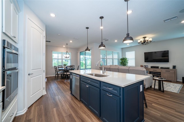 kitchen with visible vents, a sink, blue cabinetry, appliances with stainless steel finishes, and light countertops