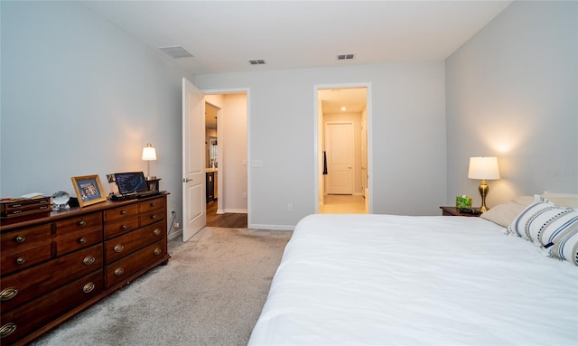 bedroom featuring light carpet, visible vents, and baseboards