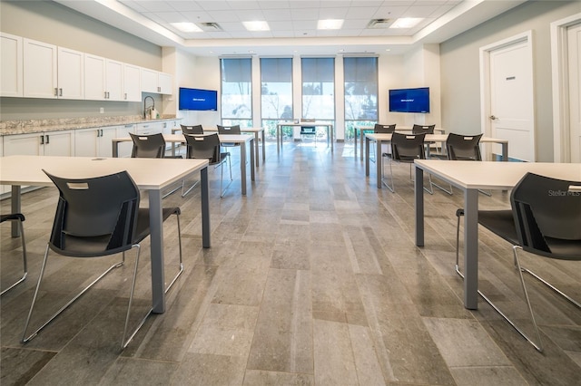 interior space with visible vents, floor to ceiling windows, a paneled ceiling, and wood finished floors