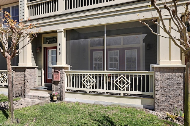 property entrance with a balcony and covered porch