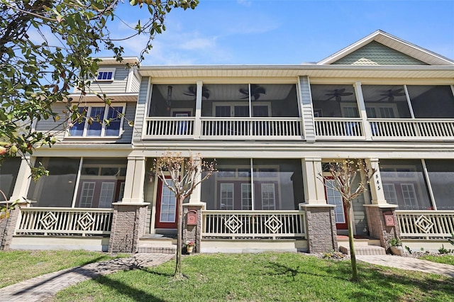 view of front of property featuring covered porch, ceiling fan, and a sunroom