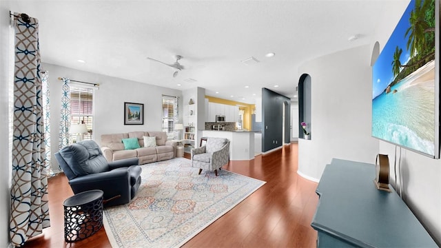 living room with visible vents, arched walkways, ceiling fan, wood finished floors, and recessed lighting