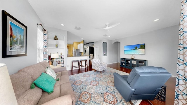 living area with arched walkways, recessed lighting, visible vents, a ceiling fan, and wood finished floors