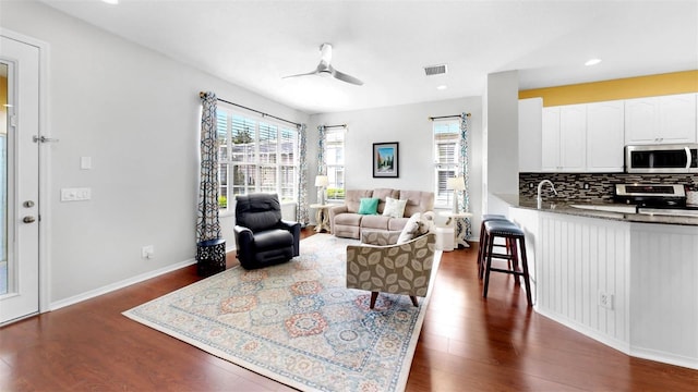 living room featuring baseboards, visible vents, dark wood-style floors, ceiling fan, and recessed lighting