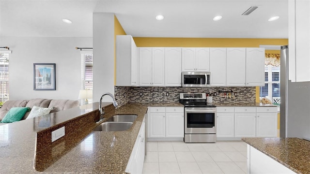 kitchen featuring appliances with stainless steel finishes, visible vents, a sink, and tasteful backsplash