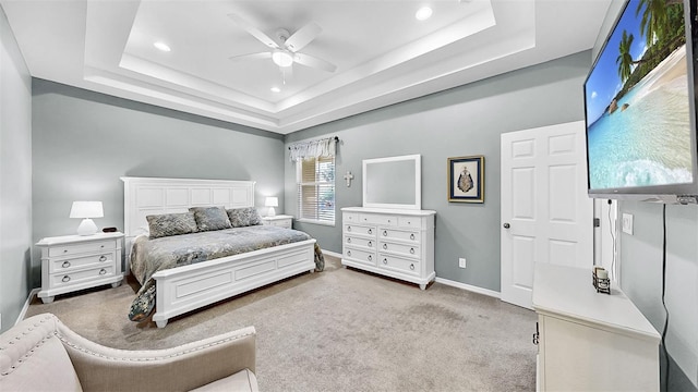 carpeted bedroom featuring a tray ceiling, recessed lighting, a ceiling fan, and baseboards