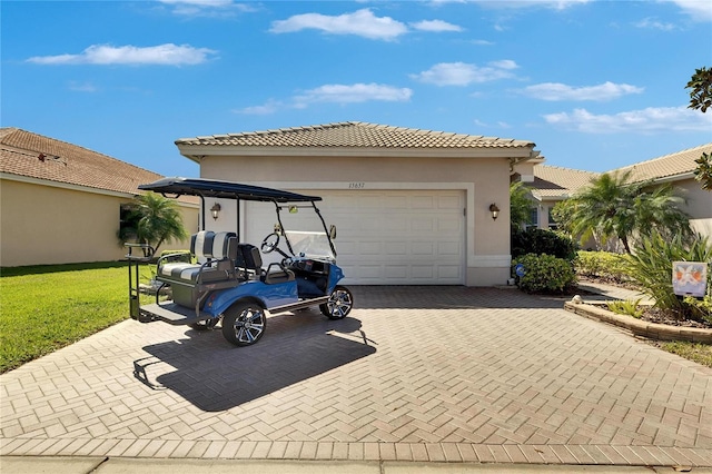 view of front of house featuring stucco siding, decorative driveway, a front yard, a garage, and a tiled roof