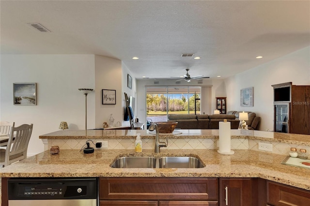 kitchen with dishwasher, light stone countertops, visible vents, and a sink