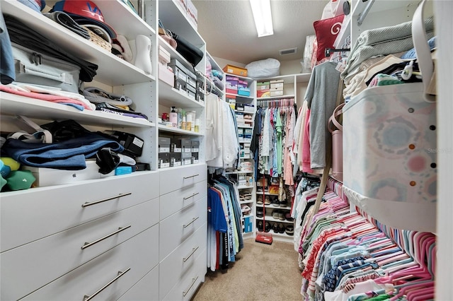 walk in closet featuring light colored carpet