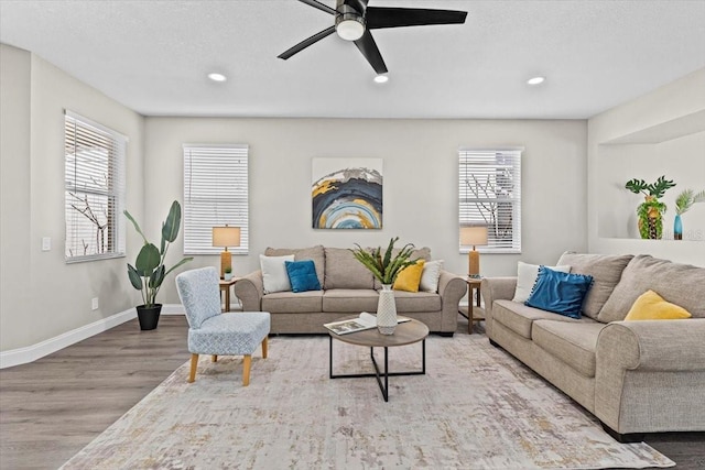 living area with a wealth of natural light, recessed lighting, baseboards, and wood finished floors