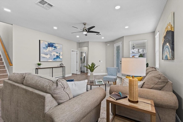 living area featuring visible vents, a ceiling fan, wood finished floors, recessed lighting, and stairs