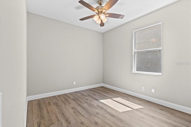 empty room with baseboards, wood finished floors, and a ceiling fan