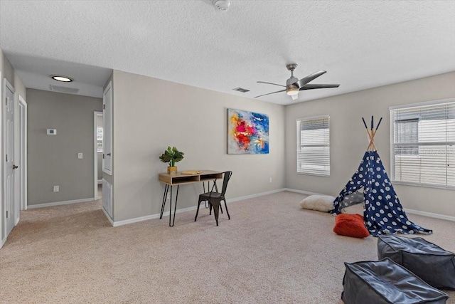 game room featuring visible vents, baseboards, carpet, a textured ceiling, and a ceiling fan