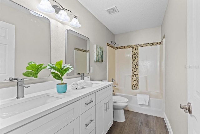 bathroom with a sink, visible vents, toilet, and a textured ceiling