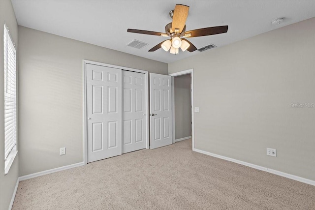 unfurnished bedroom featuring visible vents, baseboards, carpet, and a closet