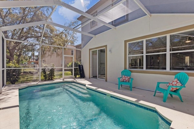 outdoor pool with glass enclosure and a patio