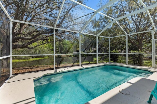 outdoor pool featuring glass enclosure and a patio area