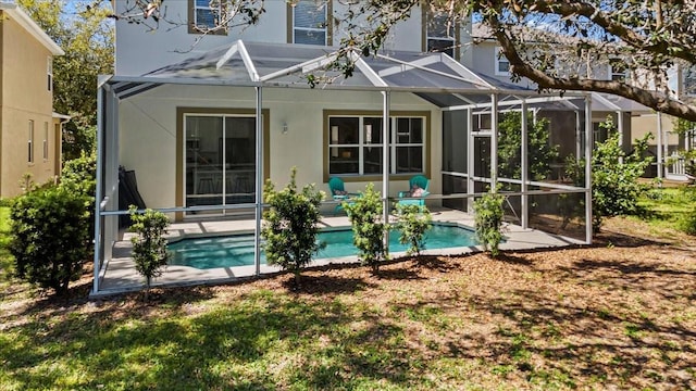 rear view of house with a patio, an outdoor pool, and a lanai