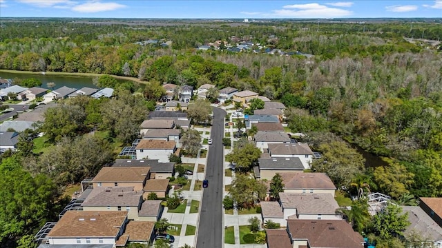 drone / aerial view with a forest view, a residential view, and a water view