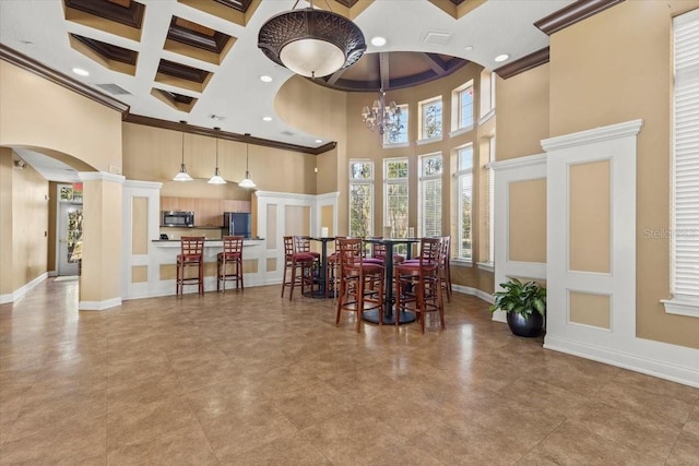 dining area with arched walkways, coffered ceiling, a high ceiling, and crown molding