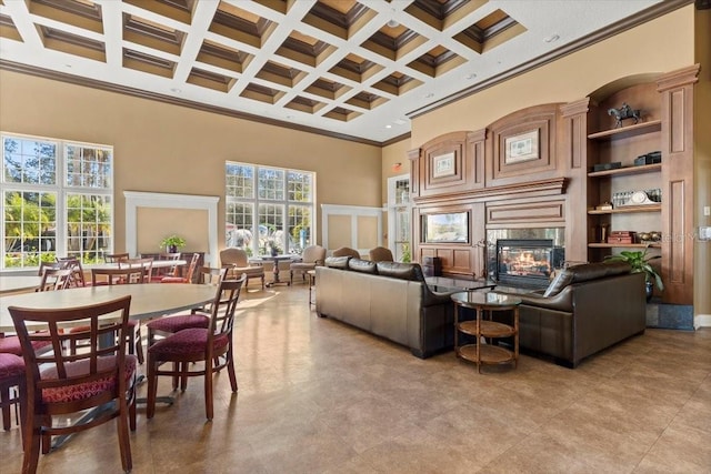 living area with coffered ceiling, a premium fireplace, a high ceiling, ornamental molding, and beamed ceiling