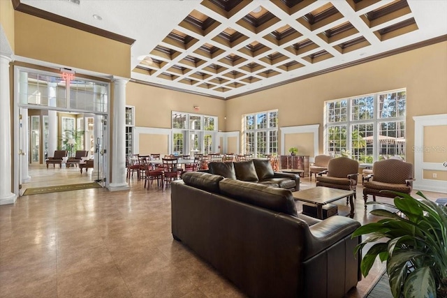 living room featuring decorative columns, plenty of natural light, and a towering ceiling