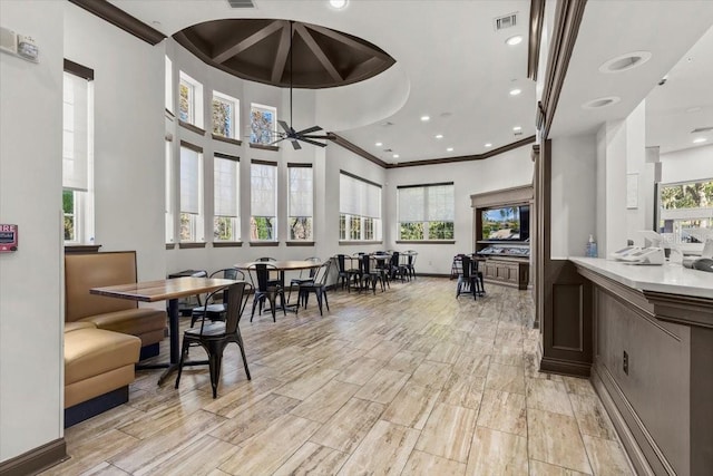 dining area featuring visible vents, plenty of natural light, light wood-style floors, and crown molding