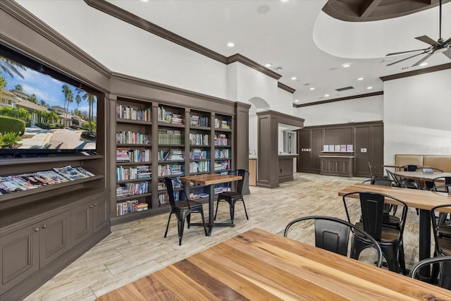 office with ornate columns, light wood-style floors, ceiling fan, and ornamental molding