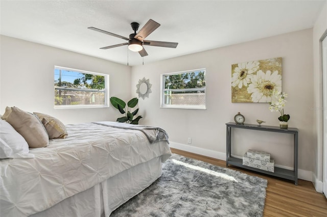 bedroom featuring a ceiling fan, baseboards, and wood finished floors