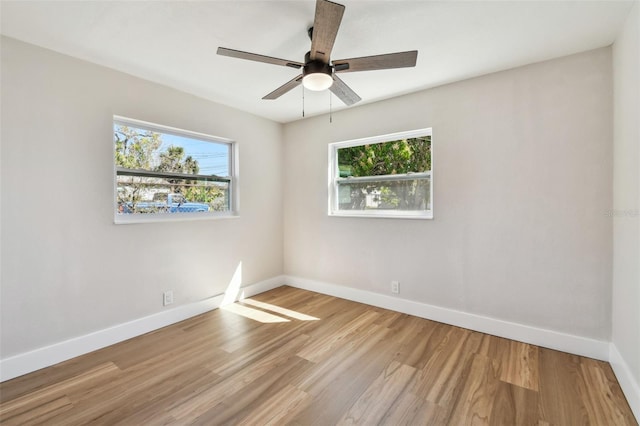 unfurnished room featuring light wood-type flooring, baseboards, and a healthy amount of sunlight