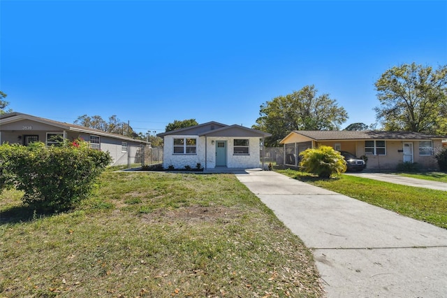 view of front of property with concrete driveway, a front yard, and fence