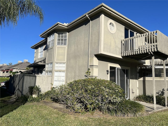 view of property exterior featuring stucco siding and fence