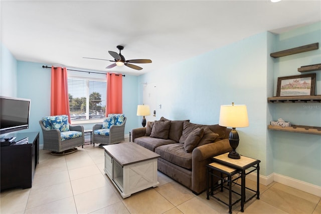 living room with light tile patterned floors, baseboards, and ceiling fan