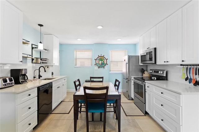 kitchen with a sink, stainless steel appliances, tasteful backsplash, and light tile patterned flooring