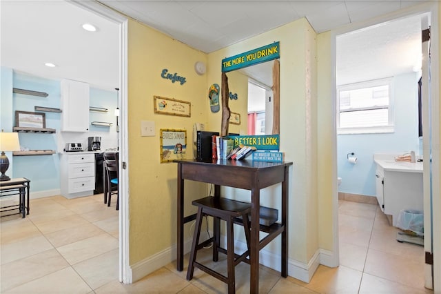 hallway featuring light tile patterned floors, baseboards, and recessed lighting