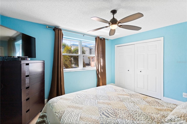 bedroom with a closet, baseboards, a textured ceiling, and ceiling fan