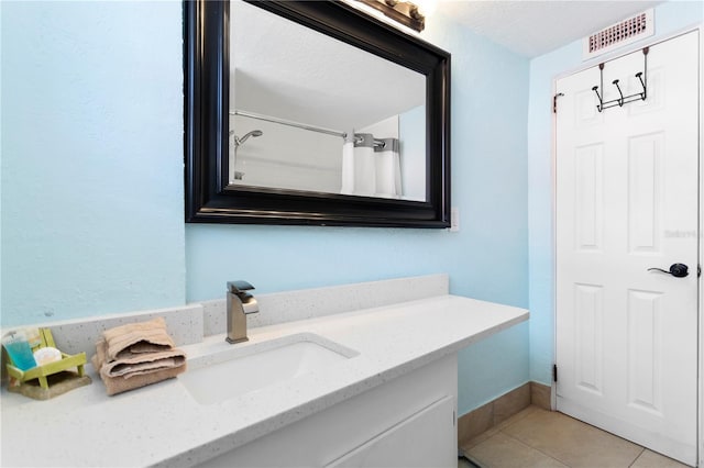 bathroom featuring visible vents, baseboards, a shower with shower curtain, tile patterned floors, and vanity