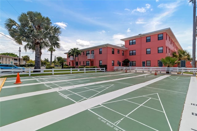 view of community featuring shuffleboard and fence