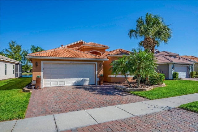 view of front facade featuring a tile roof, a front yard, stucco siding, decorative driveway, and an attached garage